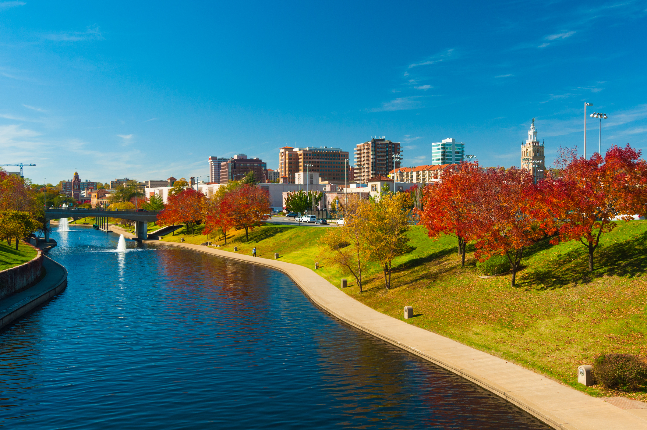 Skyline of the Country Club Plaza District in Kansas City, MO, with Brush Creek and a riverbank park in the foreground.  Picture taken during Autumn.